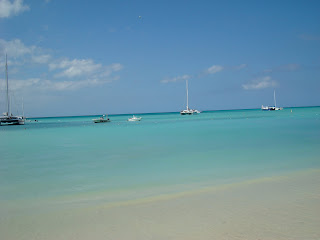 Beach and ocean in Aruba with boats in background