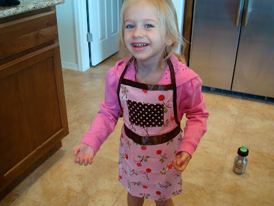 Young girl in kitchen wearing apron