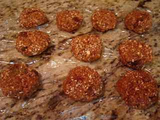 Formed oatmeal raisin cookies on plastic wrap on countertop