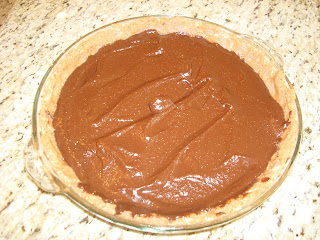 Raw Vegan Chocolate Pie in clear pie plate on countertop