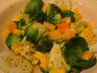 Mixed vegetables and oranges in bowl with dressing