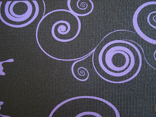 Black yoga mat showing purple designs