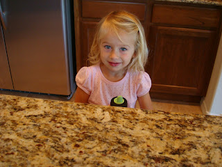 Young Girl standing behind countertop in kitchen