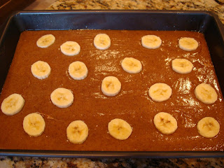 Side view of cake batter in baking pan with bananas on top
