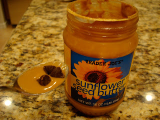 Jar of Trader Joe's Sunflower Seed Butter with spoon holding butter with chocolate chips