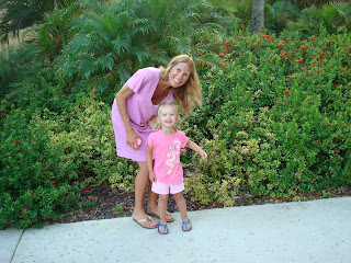 Woman and young girl standing in front of bushes smiling