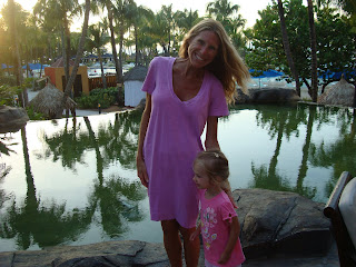 Woman and young girl standing in front of pool at dusk