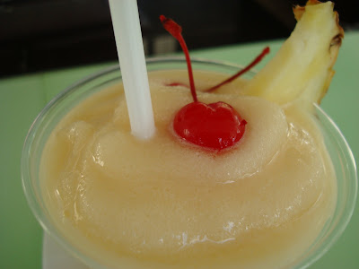 Close up of Pina Colada topped with cherry and pineapple slice