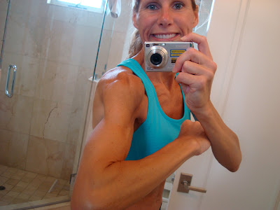 Woman flexing arms showing muscles in mirror