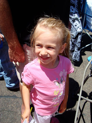 Young girl standing on pavement smiling