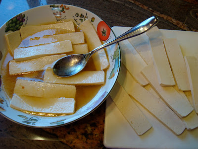 Sliced tofu being placed in marinade