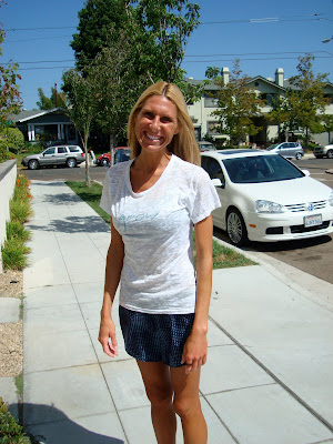Woman in white shirt and skirt on sidewalk outside