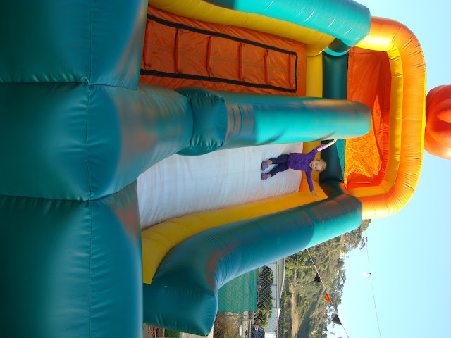Young girl sliding down giant blow up slide