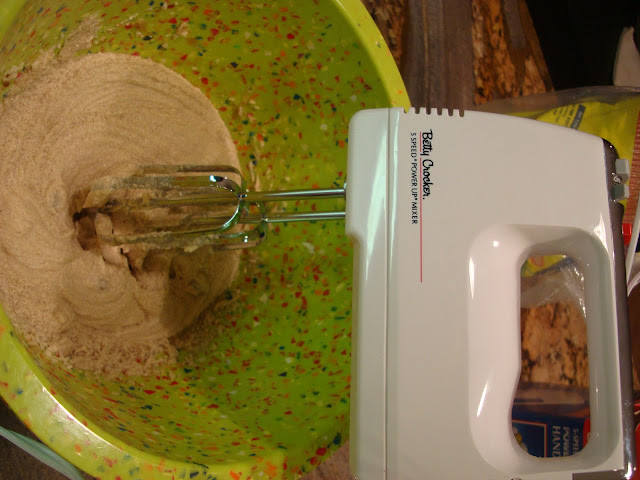 Hand mixer mixing ibutter and sugars