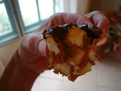 Hand holding GF Peanut Butter Marshmallow Bars with Vegan Chocolate Frosting showing marshmallows