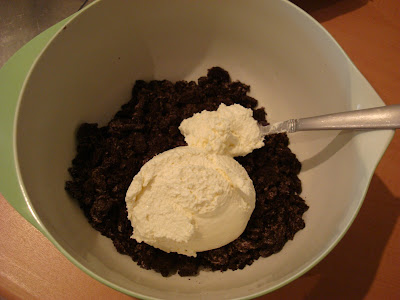 Cream cheese added to crushed Oreos in bowl