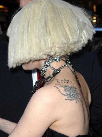 Picture of Lady Gaga's peace sign wrist tattoo and words tattoo on her arm