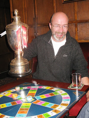 Mr A and a large silver trophy with the Triv board