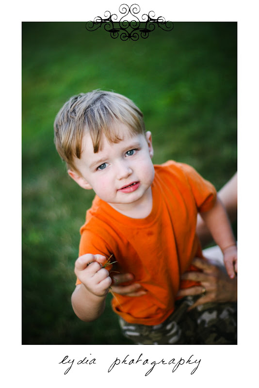 Little boy holding some grass in his hand at lifestyle kids portraits on a farm in Indiana, Pennsylvania