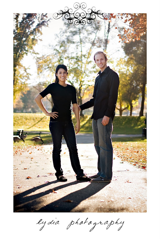 Bride posing with groom holding bride's arm at lifestyle park engagement portraits in Auburn, California