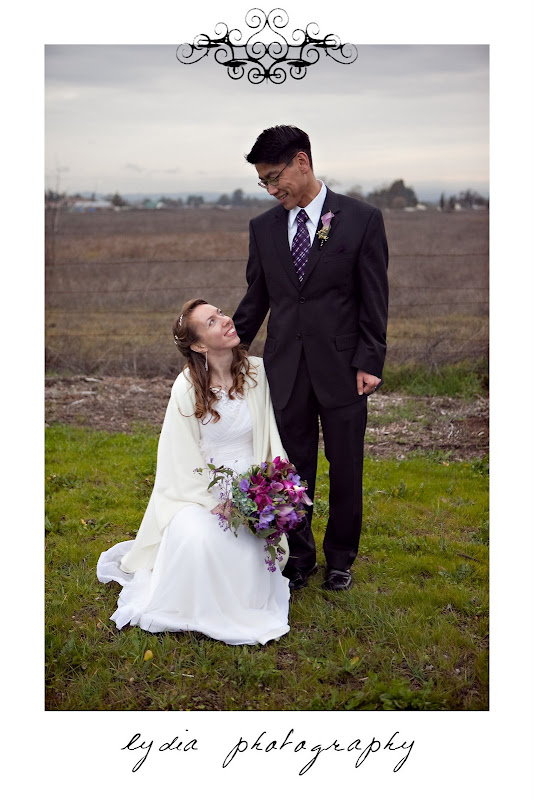 Groom looking down at his bride at purple, winter wedding in Santa Rosa, California