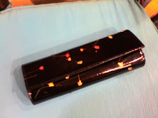 Bolso de charol negro con flores secas incrustadas