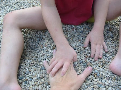 Photo of Joy's hands pulling JoyMama's hand into the gravel