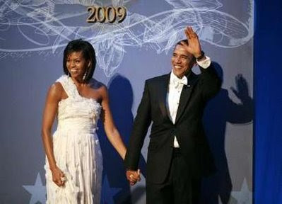U.S. President Barack Obama waves as he stands with first lady Michelle Obama.
