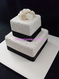 2 tier square stacked cake with piped hearts and silver cashous with sugar roses..