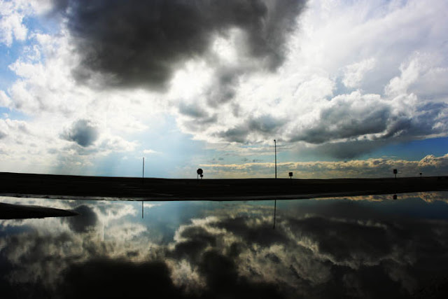 A reflection of clouds and sky from a flooded New Mexico rest area.