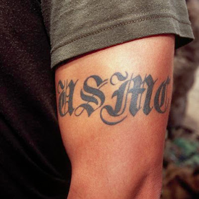 Lettering tattoo on a muscled man's arm.