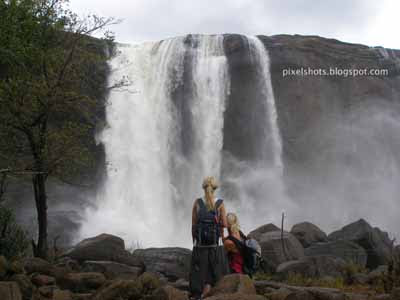 tourists watching athirapally waterfalls,kerala tourism,kerala tour destinations,waterfalls in kerala,7 wonders of kerala,athirapilly,tourism in kerala