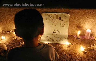 child praying with candles around him and a note saying proud to be an indian,photograph from the community candle prayers taken by professional media photographers