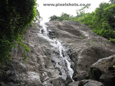 water falls in thusharagiri in summer season,narrow line of water flowing through the rocks inside the forest in thusharagiri-calicut-kerala,thusharagiri waterfalls-kerala