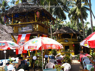 palm thatched beach cafes with watchtower serving tables kerala coffee house beach cafe,beach side restaurants with watchtower,palm thatched beach hotels,sea side restaurants made of bamboo and palm leaves,affordable beach side hotels in Kerala