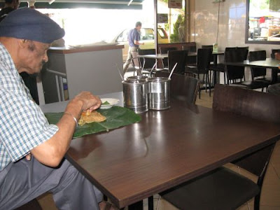 man enjoying his roti canai at Kashmir Cafes