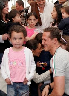 Former Formula One champion Michael Schumacher smiles at Nidalin Mendoza, 5, during his visit to shelter for people left homeless by Thursday's 6.1-magnitude earthquake in Poasito de Vara Blanca, Costa Rica, Wednesday, Jan. 14, 2009. (AP Photo/Kent Gilbert)
