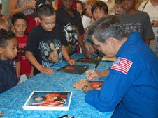 Bob Cabana autographs photos for young space enthusiasts in Minneapolis.