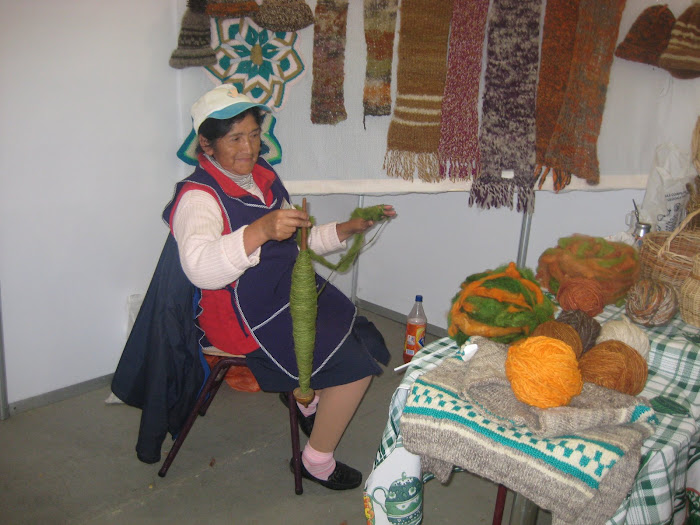Mapuche  hilando lana con un  huso con una papa
