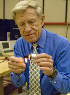 Caption: University of Utah physicist Orest Symko holds a match to a small heat engine that produces a high-pitched tone by converting heat into sound. Symko's research team is combining such heat engines with existing technology that turns sound into electricity, resulting in devices that can harness solar energy in a new way, cool computers and other electrical devices, Credit: University of Utah, Usage Restrictions: None.