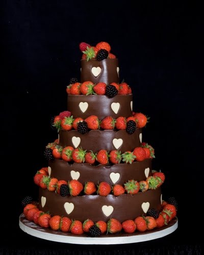 Dark chocolate wedding cake over three tiers with lots of strawberries and a