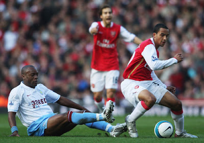 Theo Walcott of Arsenal is tackled by Nigel Reo-Coker of Aston Villa