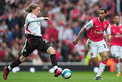 Theo Walcott of Arsenal closes down Leiva Lucas of Liverpool.
