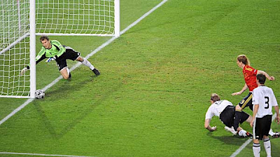 Germany goalkeeper Jens Lehmann (left) dives for the ball kicked by Spanish forward Fernando Torres (second right) in front of German defender Per Mertesacker (center) and defender Arne Friedrich (right).