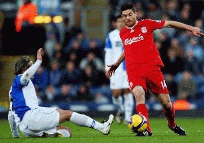Liverpool's second scorer Xabi Alonso is challenged by Tugay of Blackburn Rovers