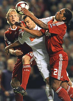 Liverpool's Dutch forward Dirk Kuyt (L) and English defender Glen Johnson (R) challenge Debrecen's Hungarian midfielder Peter Szakaly. The Reds won the match 1-0 thanks to Kuyt's goal at the end of the first half.