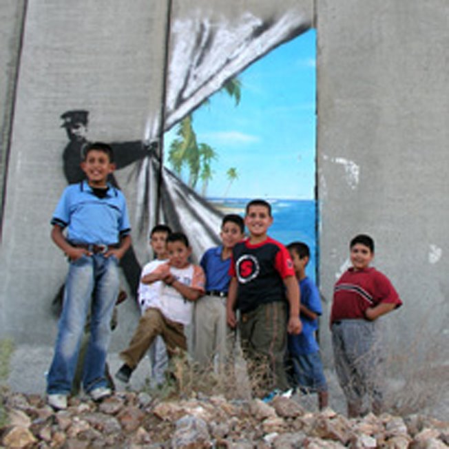 LA felicidad de niños palestinos viendo el hueco de libertad pintado en la pared que coloniza...