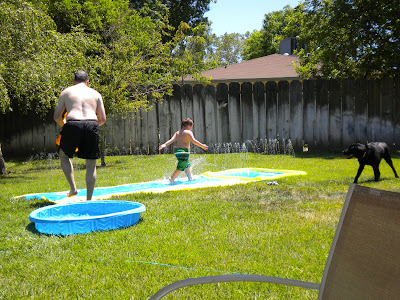 Brian walking down the slip-n-slide with John following him. Dagan standing back, looking on