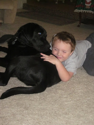 Brian lying on top of Dagan, giving him a hug with a big smile on his face. Dagan is looking over his shoulder at Brian trying to figure out what the heck is going on