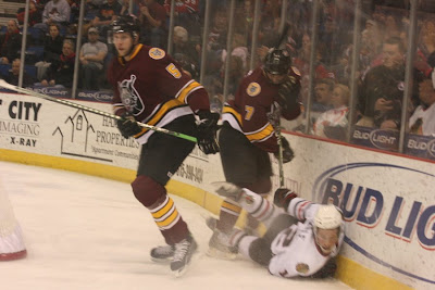 Credit:Jane Rickard,Jack Skille continues his fall against the boards, please note how high his helmet is on his head, resting at the crown.Will it give him any protection when his head hits the boards in a few seconds? Note only the hair line up is protected in the front